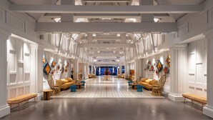 A spacious hotel lobby with high ceilings, modern furniture, and decorative wall art. - SAii Laguna Phuket (Choeng Thale)