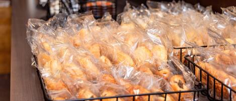 A tray of baked goods in plastic bags on a metal rack.