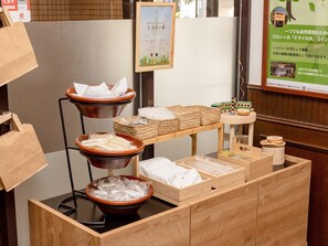 Una recepción con un mostrador de madera, un cartel enmarcado y un letrero con texto en japonés.
