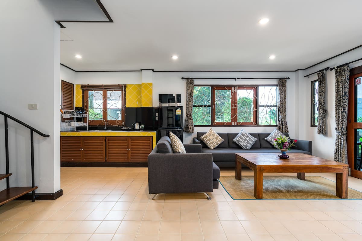 A modern living area with a sofa, coffee table, and kitchen in the background.