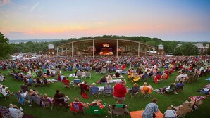 A large outdoor amphitheater with tiered seating and a stage at the front.