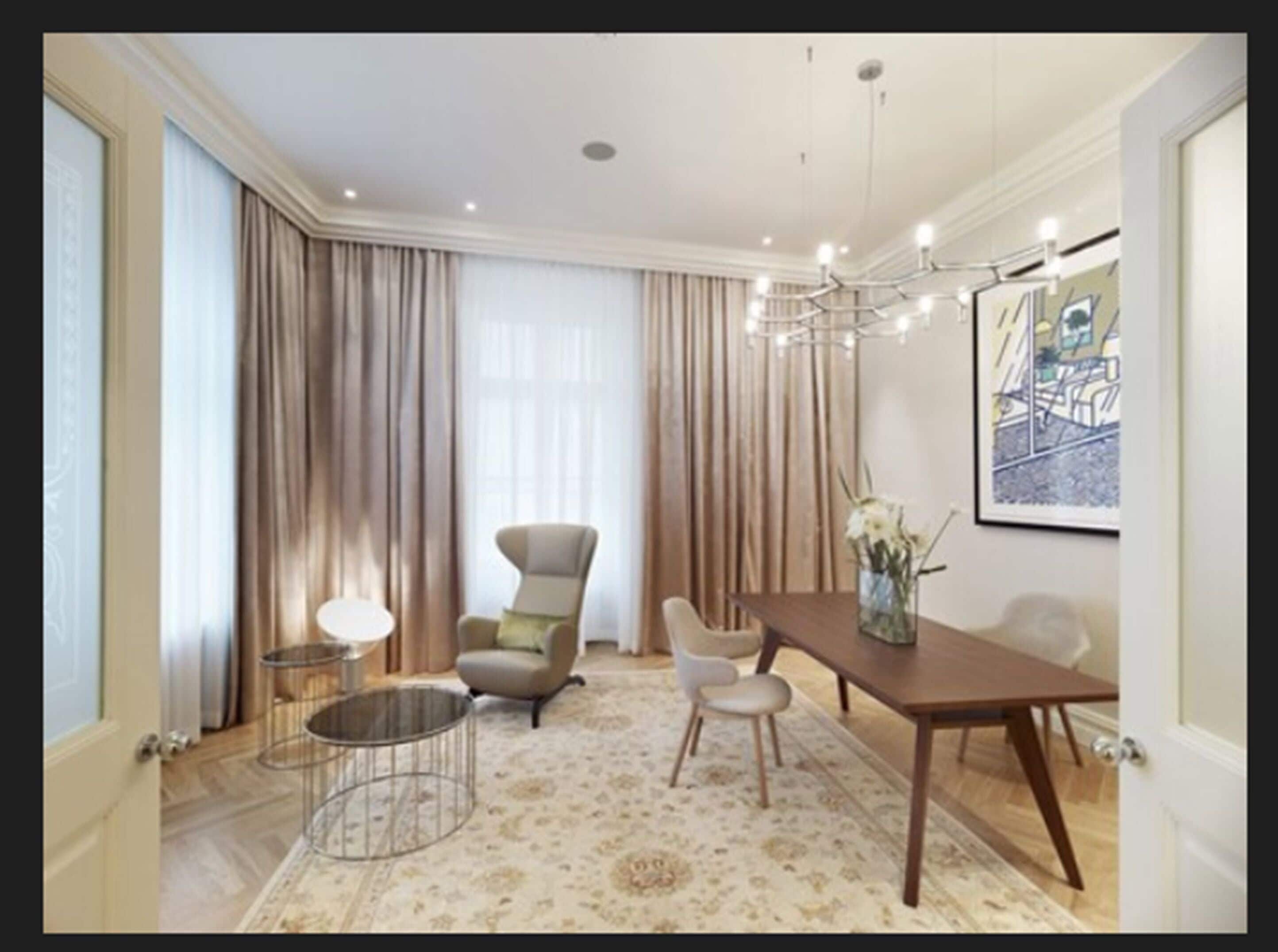 A spacious dining area with a wooden table, two chairs, a round coffee table, and a chandelier.