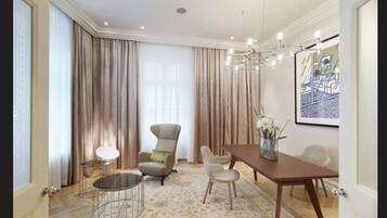 A spacious dining area with a wooden table, two chairs, a round coffee table, and a chandelier.
