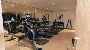 A gym with treadmills, elliptical machines, and free weights.