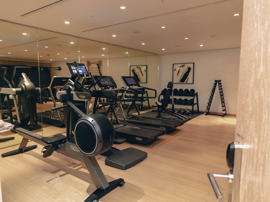 A gym with treadmills, elliptical machines, and free weights.