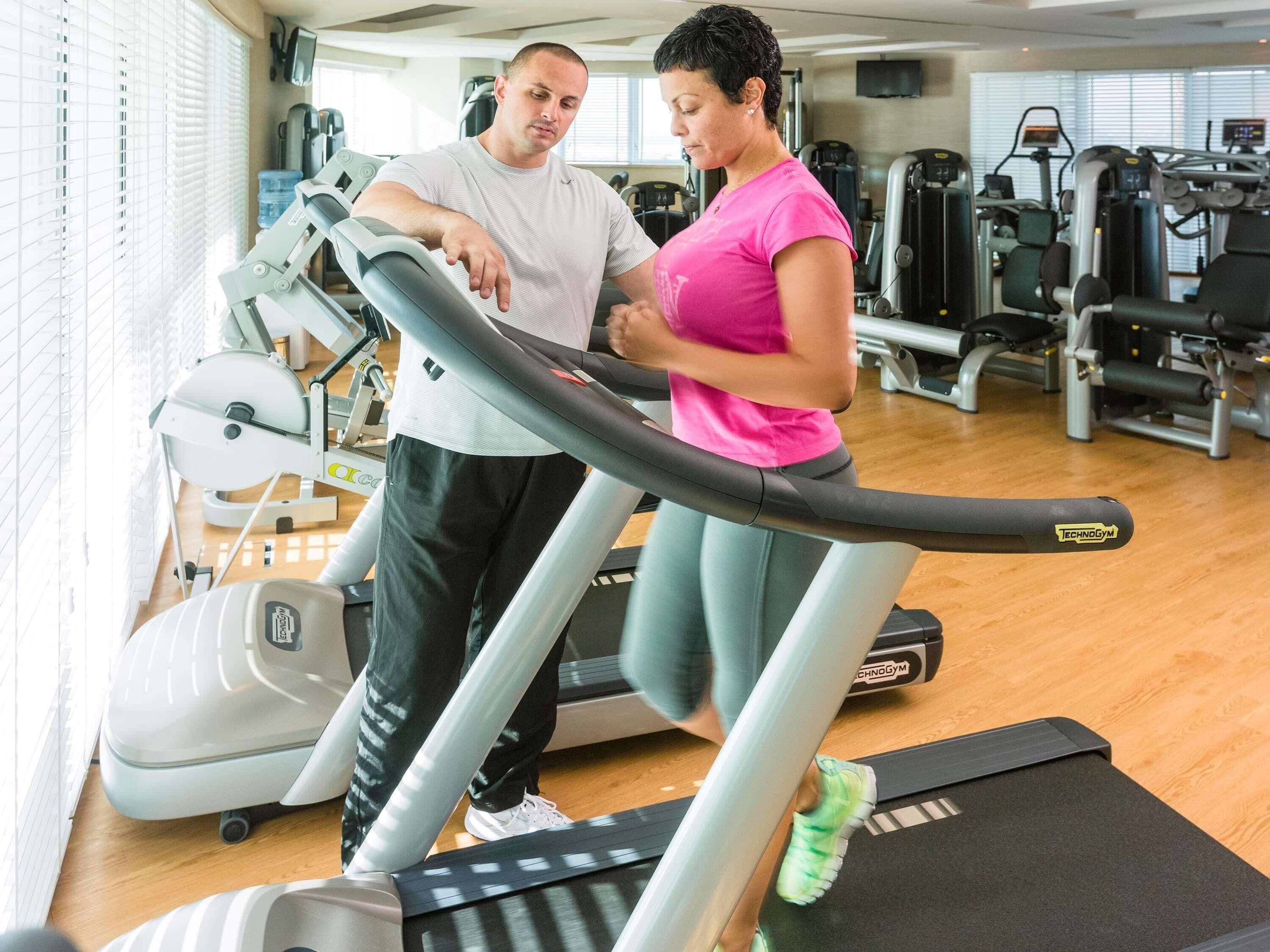 A gym with treadmills, weight machines, and a water dispenser.