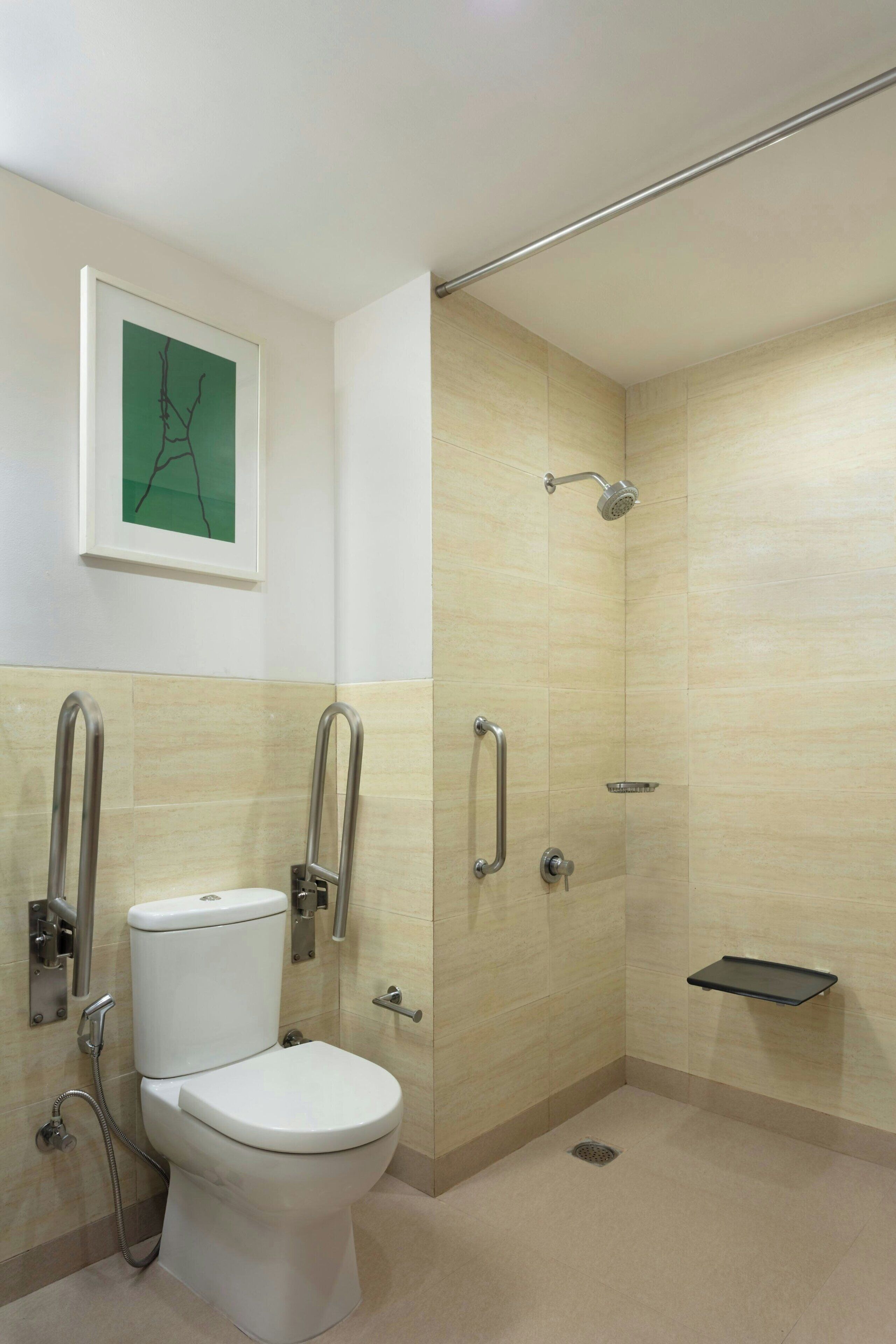 A modern bathroom with a toilet, a shower, and a grab bar.