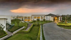 A modern hotel with a landscaped garden, a curved driveway, and a covered outdoor area. - Four Points by Sheraton New Delhi, Airport Highway (New Delhi)