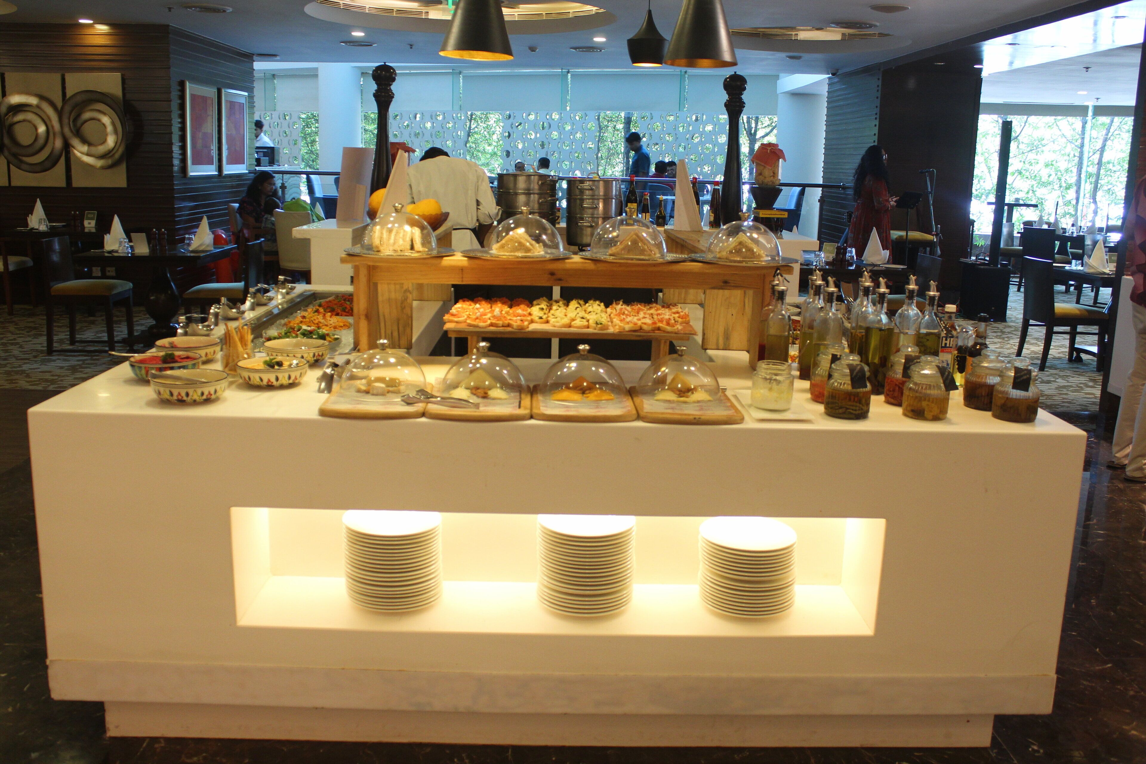 A buffet area with various food items and condiments.