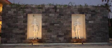 A stone wall with two niches containing statues.