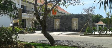 A building with a stone facade, a tree in the foreground, and a clear sky.