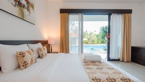 A hotel room with a large bed, a view of a swimming pool, and a balcony with curtains.