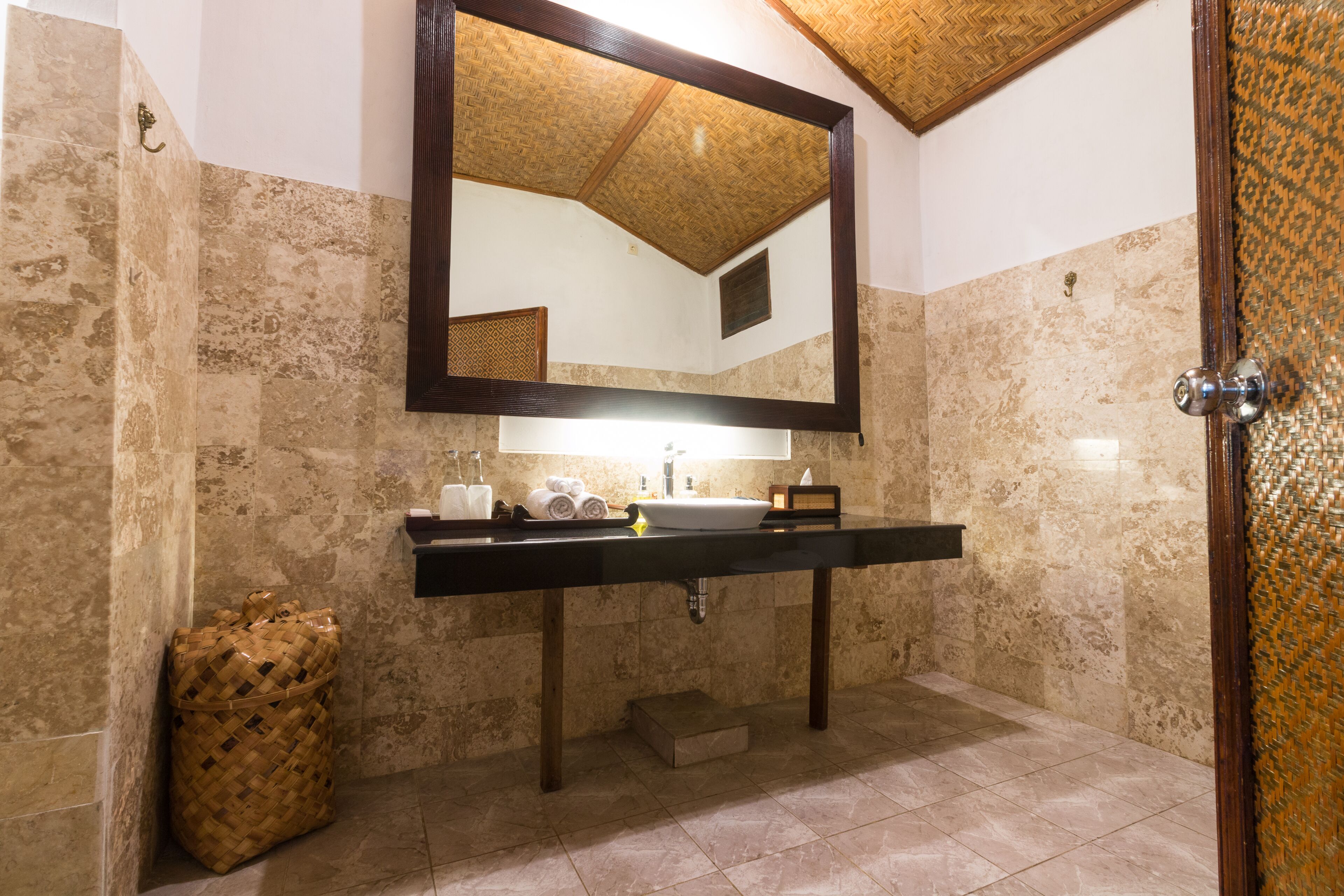 A bathroom with a large mirror, a sink, and a shower area.
