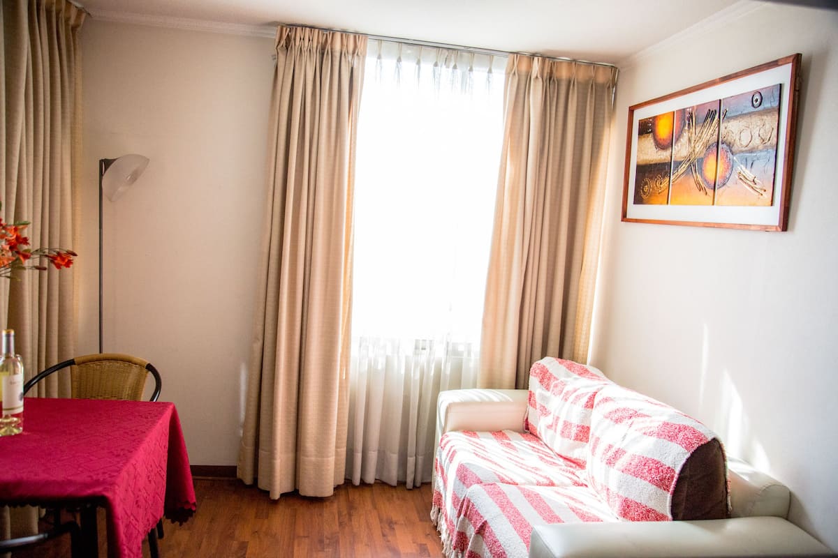 Ein Zimmer mit Esstisch, Sofa und einem Bild an der Wand.