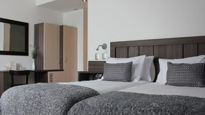 A hotel room with two beds, a wooden headboard, a bedside table with a lamp, and a mirror on the wall. - SU Merced Boutique Hotel (SANTIAGO DE CHILE)
