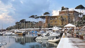 Un puerto deportivo con barcos amarrados, un edificio histórico y un cielo despejado.