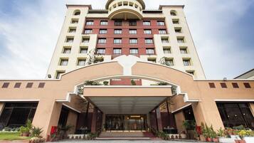 Un hotel de varios pisos con una entrada central, grandes ventanales y una fachada simétrica.