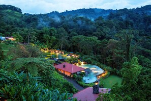 A resort with a swimming pool, surrounded by lush greenery and hills. - Peace Lodge (Vara Blanca)