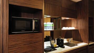 A modern kitchen with a built-in microwave, coffee maker, and a sink.