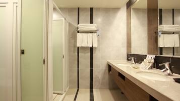 A modern bathroom with a dual sink vanity, a large mirror, and a towel rack.