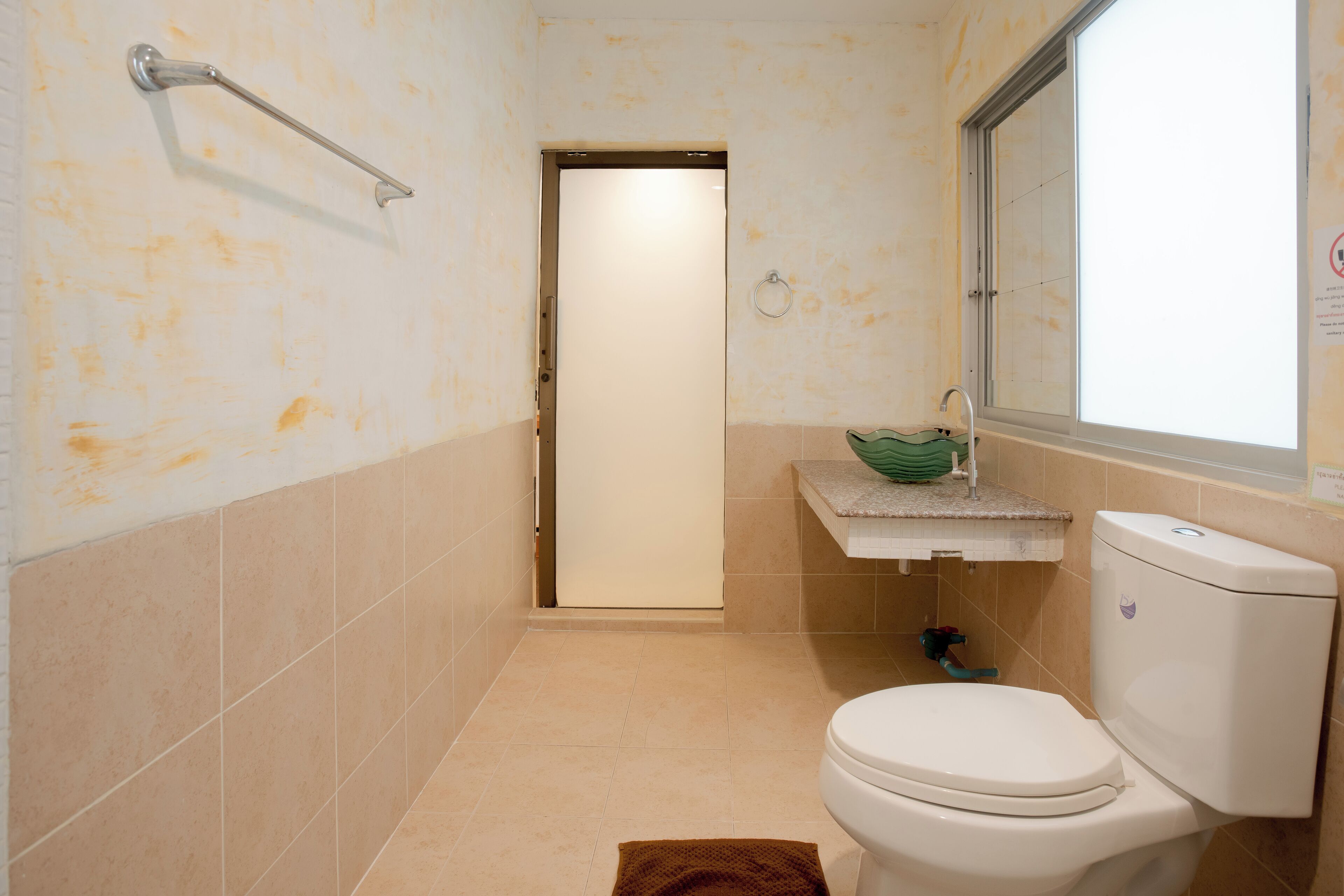 Un baño pequeño con inodoro, lavamanos y toallero.