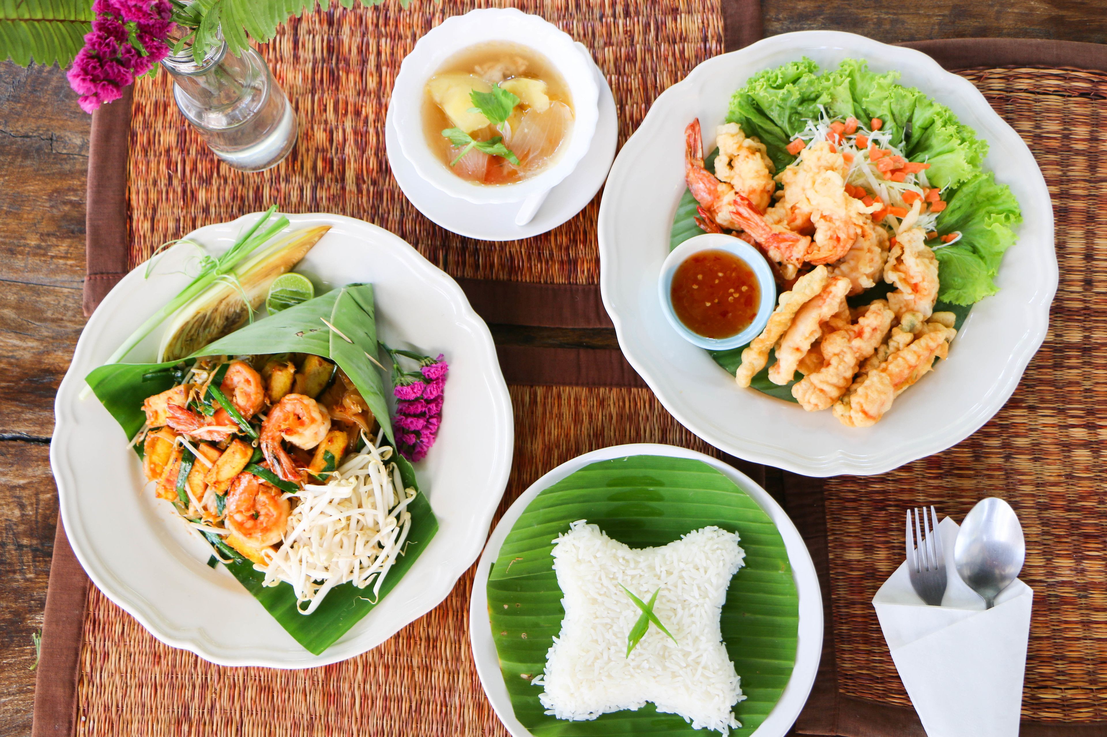 A table with various dishes including shrimp, rice, and a soup.