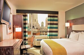 A hotel room with a bed, desk, chair, and a television. - Holiday Inn Express Manhattan Times Square South by IHG (New York)