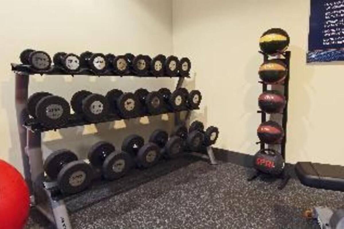 Ett gym med ett ställ med hantlar och en kettlebell.