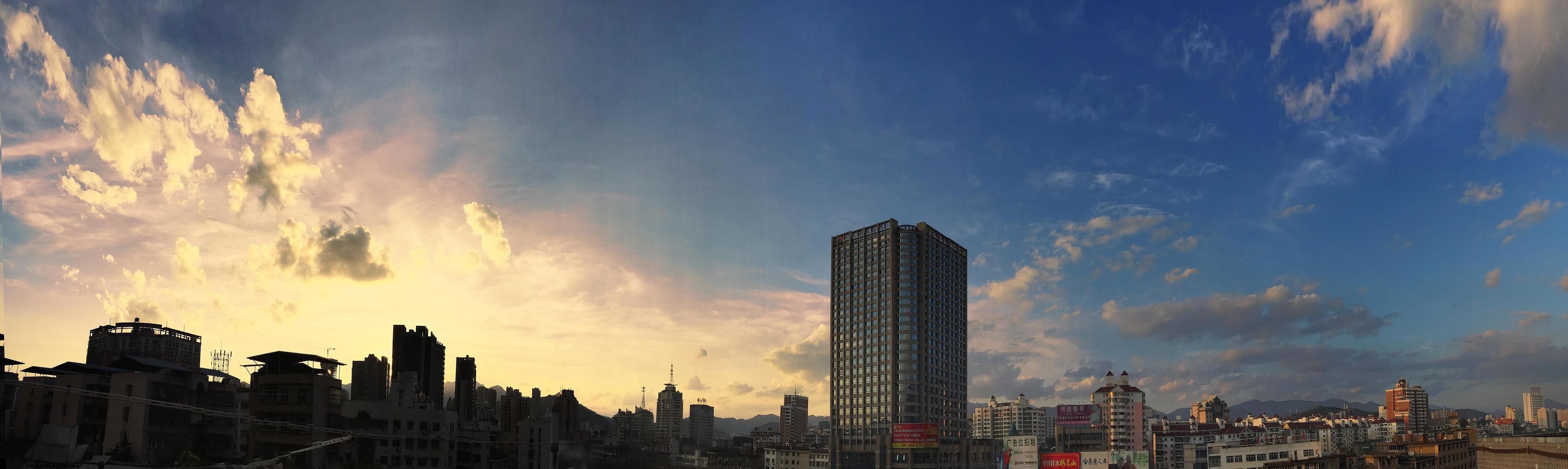A cityscape with a prominent high-rise building, various mid-rise buildings, and a mix of commercial and residential structures.