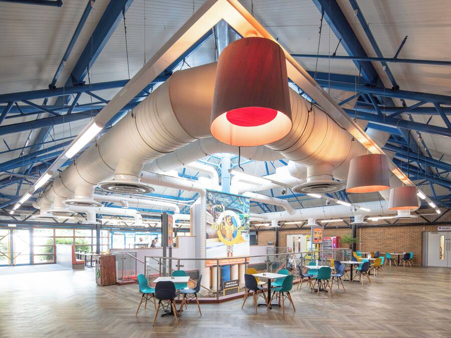 A spacious indoor area with high ceilings, exposed beams, and a modern industrial design.