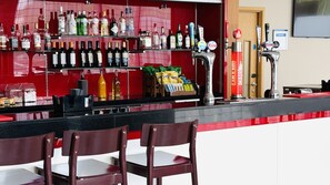 A bar area with multiple liquor bottles, a beer tap, and snack bags. - Holiday Inn Express Rotherham North by IHG (Rotherham)