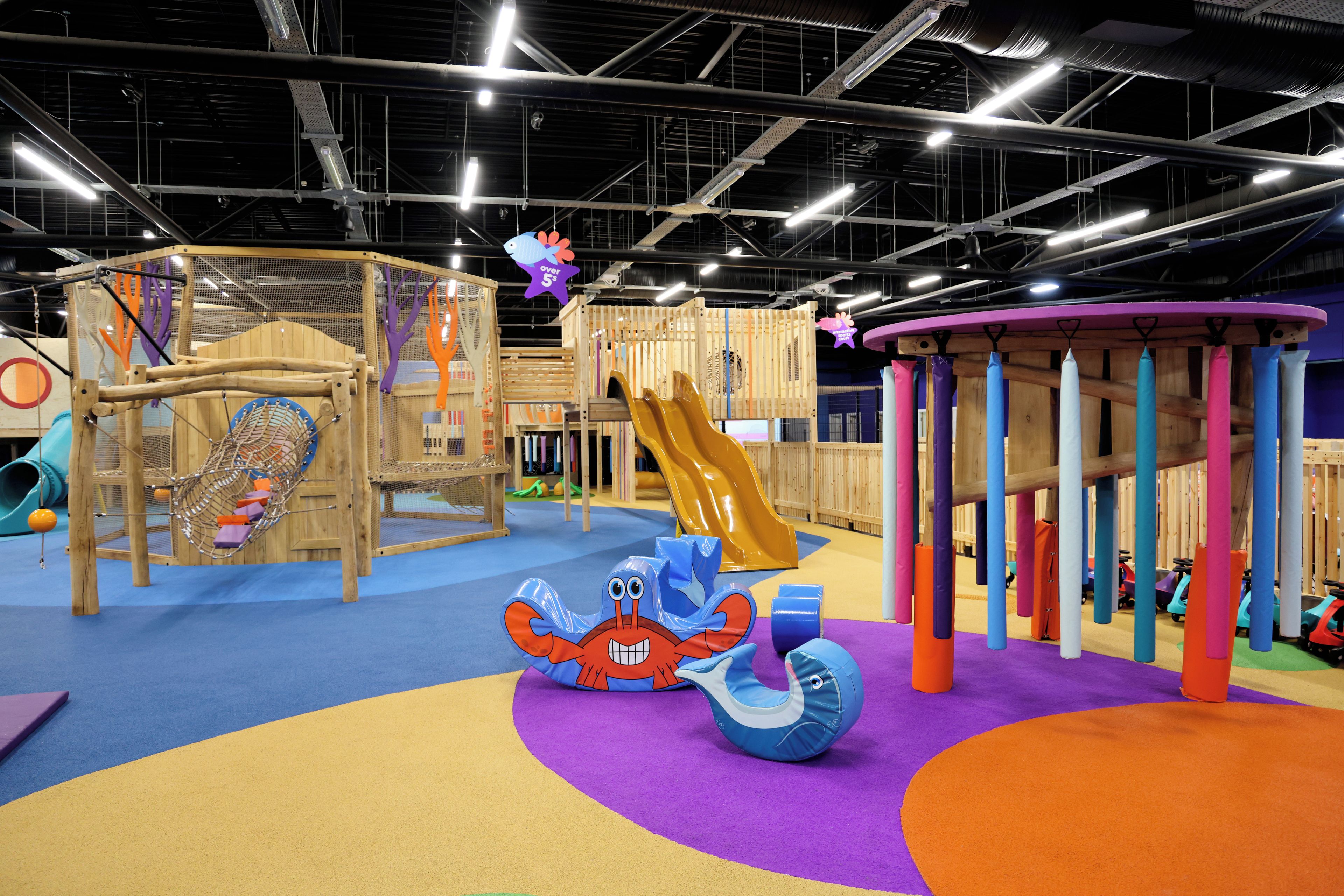 A children's play area with various play structures, including a slide and climbing frames.