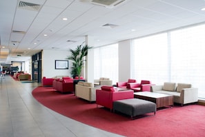 A modern hotel lobby with a red carpet, seating areas, and large windows. - Holiday Inn Express Rotherham North by IHG (Rotherham)