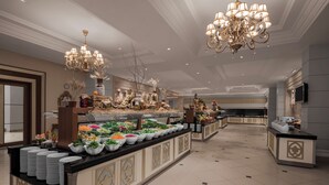 A buffet area with multiple food stations, a chandelier, and a television screen. - NG Afyon (Afyonkarahisar)