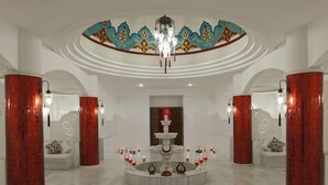 A spacious lobby with a central fountain, red pillars, and a decorative ceiling. - NG Afyon (Afyonkarahisar)