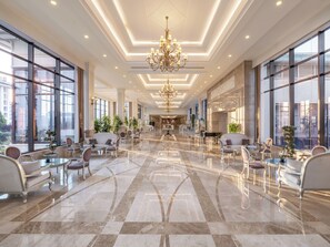 A spacious lobby with a grand chandelier, large windows, and a polished marble floor. - NG Afyon (Afyonkarahisar)