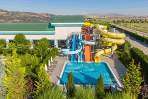 Parque acuático con piscina, toboganes y un edificio de techo verde.