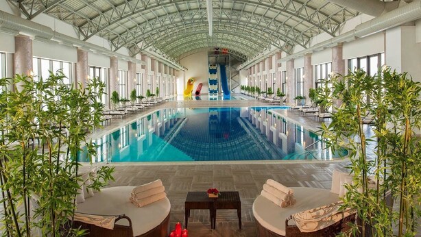 A large indoor swimming pool with a high ceiling and a slide. - NG Afyon (Afyonkarahisar)