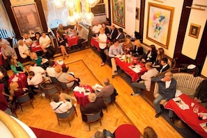 A conference room with round tables, attendees seated, and a speaker addressing the group. - Bellevue (Split)