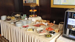 A buffet table with various food items and a coffee machine. - Bellevue (Split)