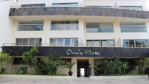 Un hôtel à plusieurs étages, doté d’une façade noire et portant l’inscription « Ocean Plaza » au rez-de-chaussée.