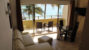 Un salon avec un balcon, un canapé, une table et des chaises.