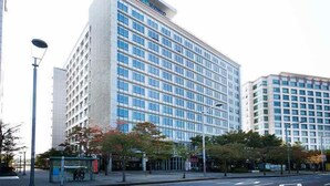 A modern high-rise hotel with a glass facade, multiple floors, and a prominent entrance. - Hotel Hu (Incheon)