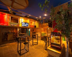 A cozy bar area with stools, a television, and a jukebox.