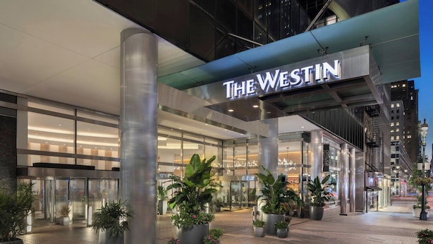 L'ingresso dell'hotel Westin, con grandi piante in vaso e una facciata moderna.