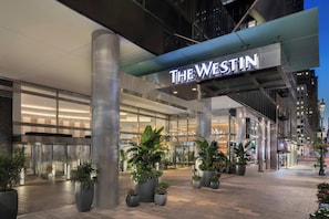 Entrada do hotel Westin com grandes vasos de plantas e fachada moderna.