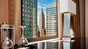 Camera d'albergo moderna con una grande finestra che offre vista sull'Empire State Building.