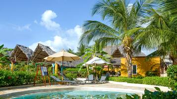 Una piscina al aire libre, sombrillas, tumbonas