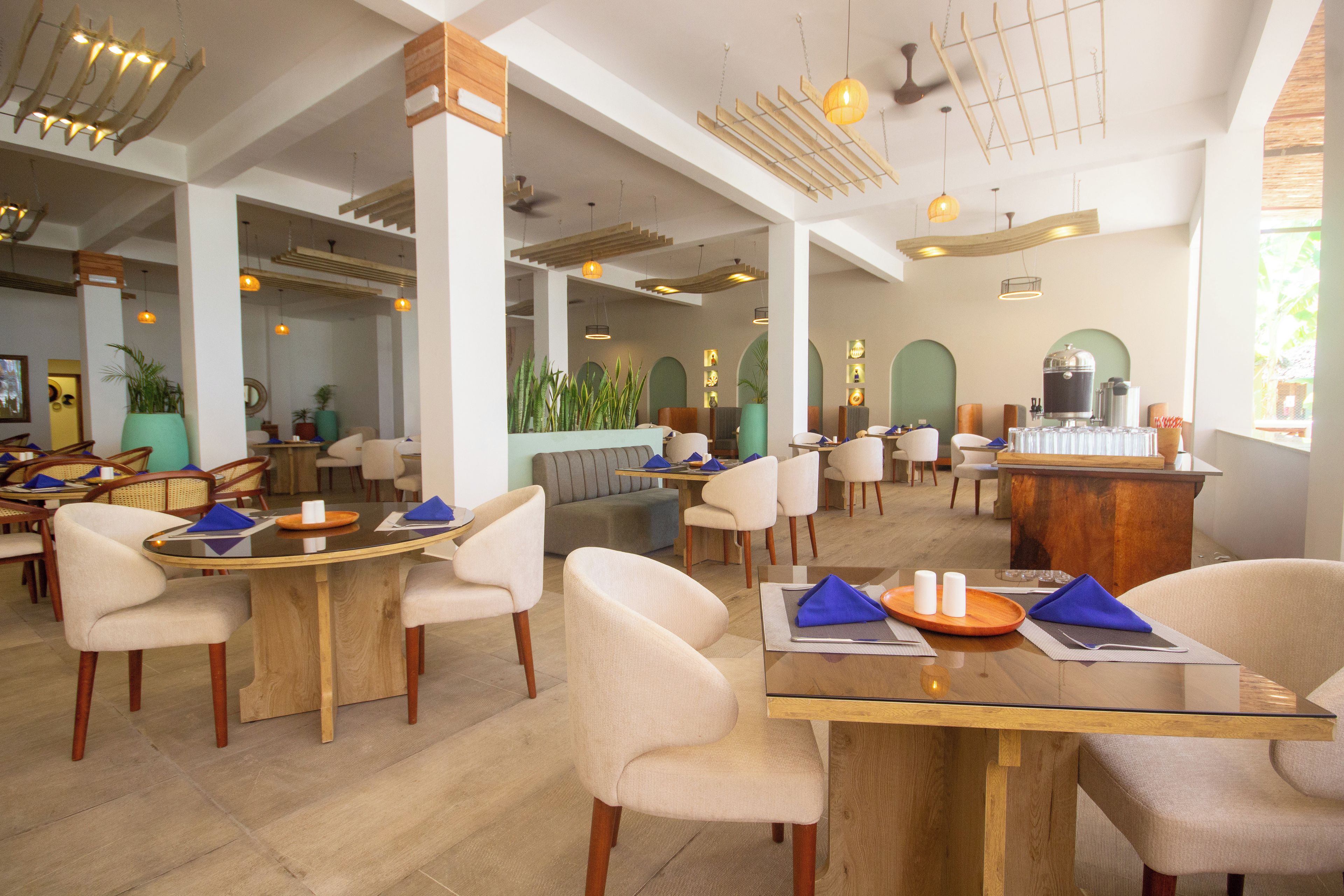 Ein geräumiges Restaurant mit hohen Decken, moderner Einrichtung und verschiedenen Sitzgelegenheiten.