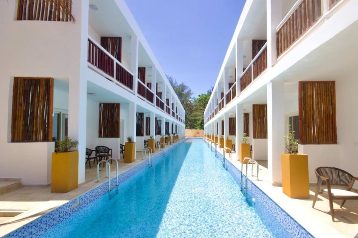 Um hotel com piscina central, várias varandas e áreas de estar ao ar livre.
